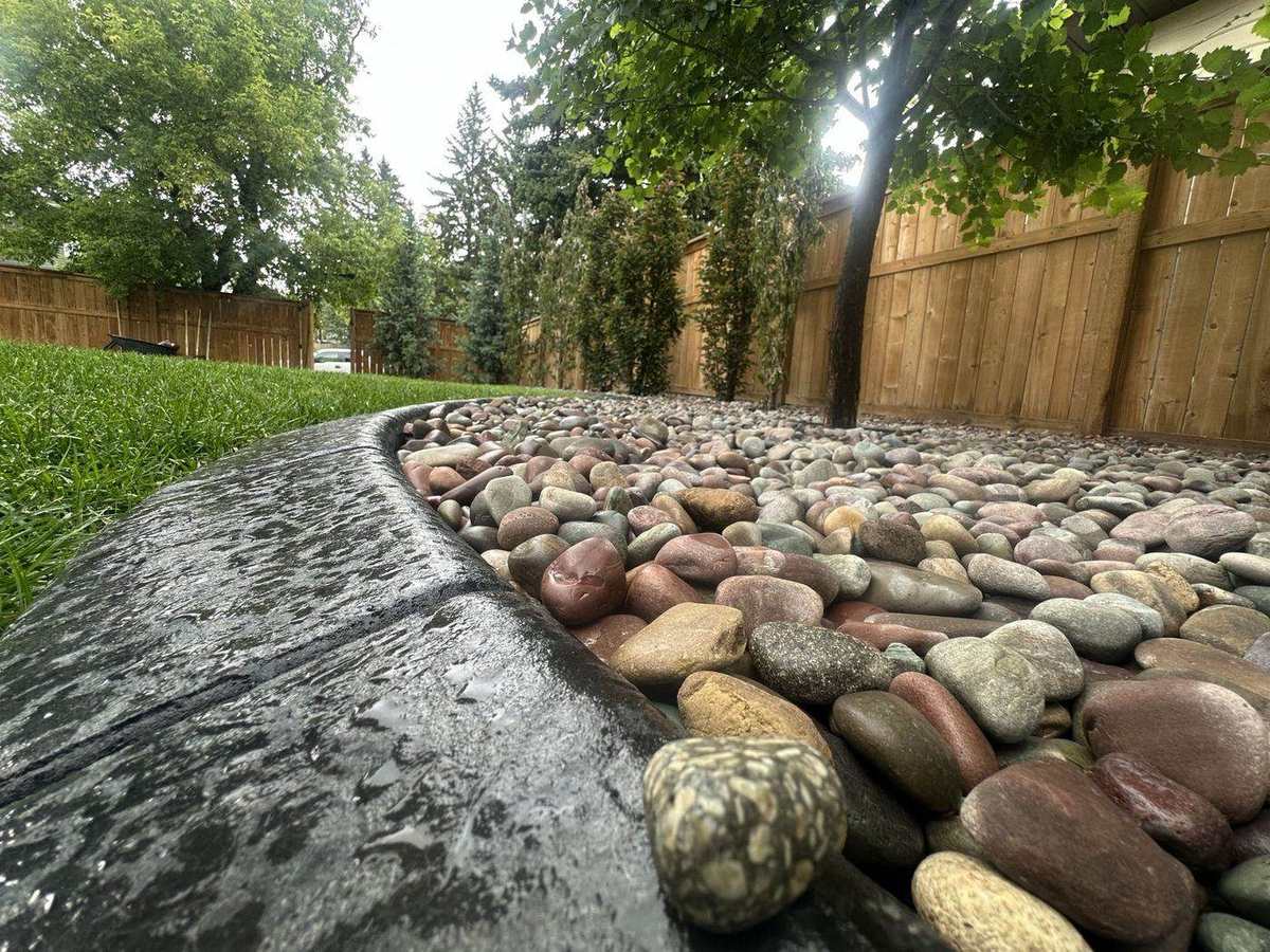 Completed decorative river-rock landscaping by BRUK